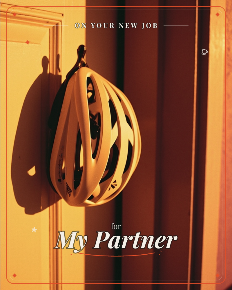 A white cycling helmet hangs from a small hook beside a doorframe, its straps and vents casting a sharp shadow across the wall, a new job e-card design