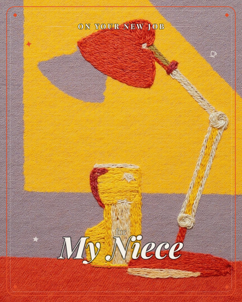 An embroidered desk lamp with a red angled shade throws a warm yellow glow across a mauve wall, its cord and hinges stitched in cream thread, a new job e-card design