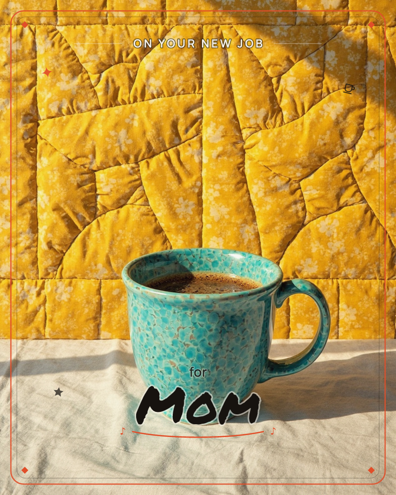 A speckled turquoise mug of black coffee sits on a pale marble counter, backed by a golden-yellow quilted blanket printed with tiny flowers, a new job e-card design