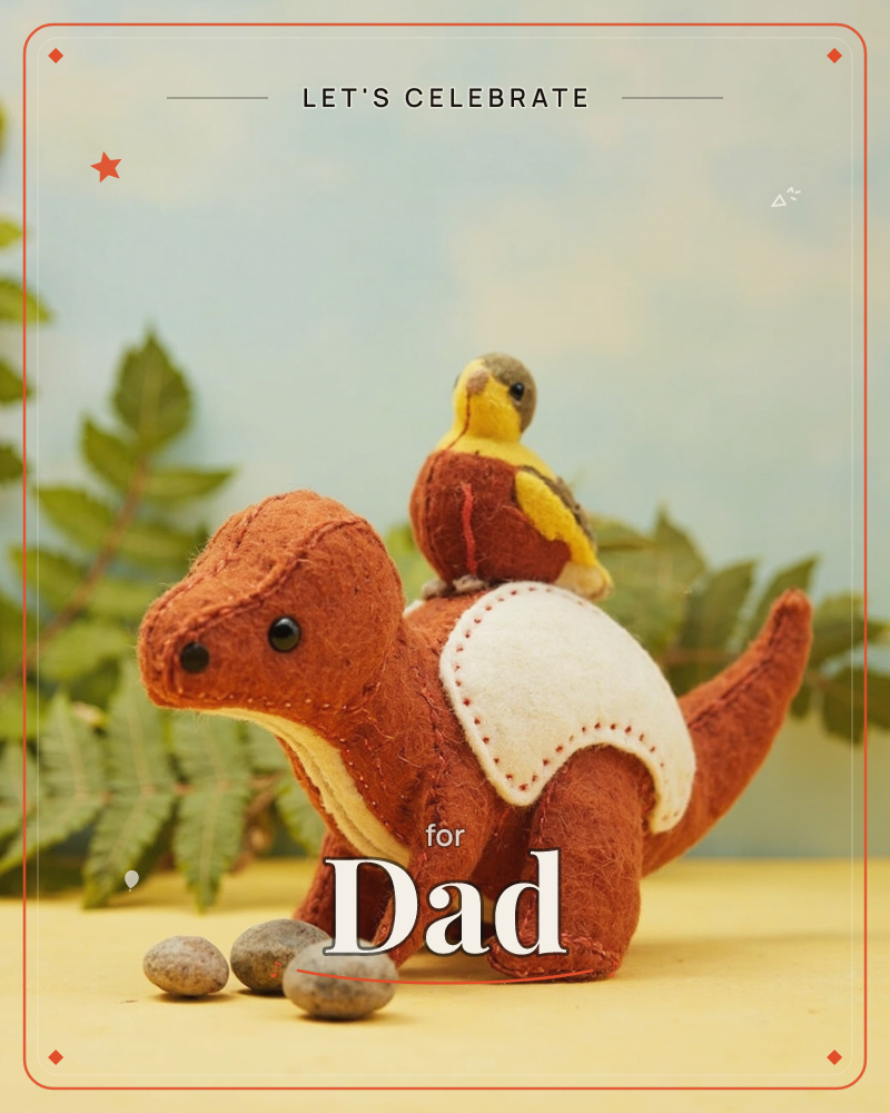 A handstitched felt dinosaur in rust orange stands among fern fronds with a small felt bird perched on its back, its cream belly patch and visible…, a party e-card design
