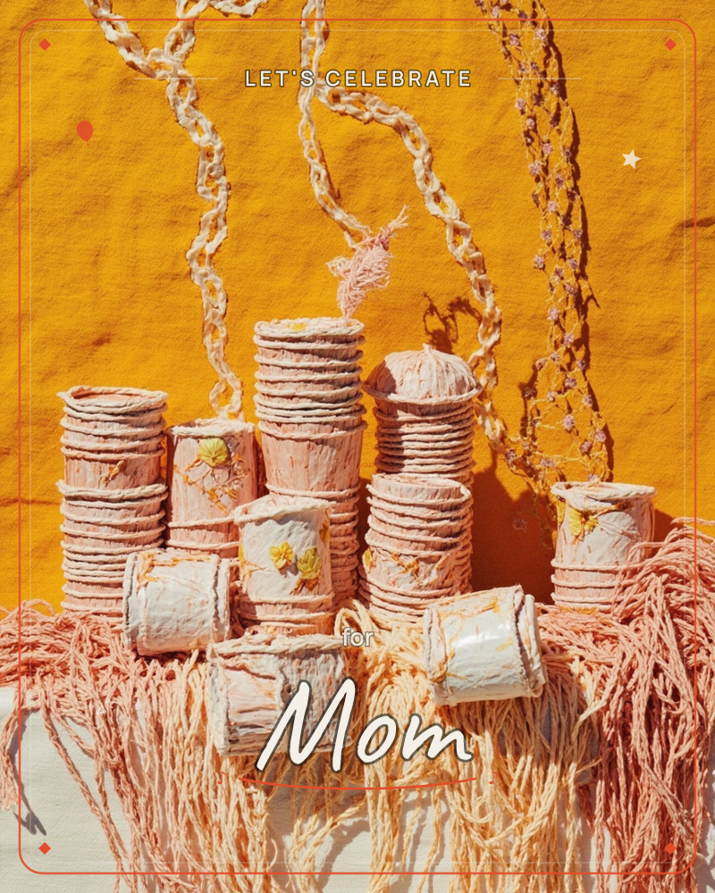 Stacked and scattered paper cylinders in blush pink stand against a bold mustard-yellow backdrop, with looped cotton cord dangling from above like…, a party e-card design