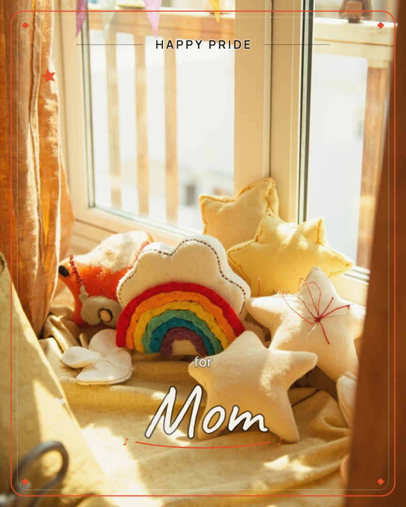 A sunlit windowsill is scattered with handmade felt cushions shaped like stars, a fluffy cloud, a stitched rainbow and a small orange fox, all resting…, a pride e-card design