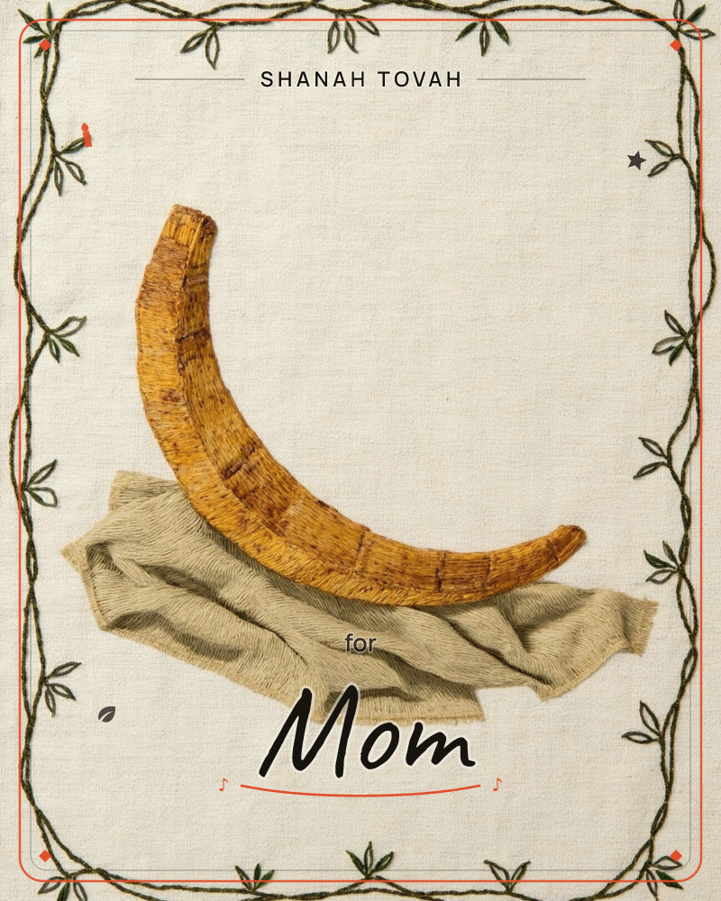 An embroidered banana, stitched in rich golden-brown thread, curves gently as it rests atop a rumpled sage-green cloth on natural linen, a rosh hashanah e-card design