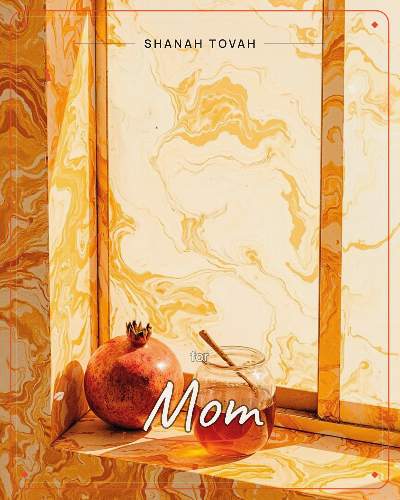 A pomegranate and a small jar of honey with a wooden dipper sit on a sunlit windowsill, framed by golden marbled panes that swirl like liquid amber light, a rosh hashanah e-card design