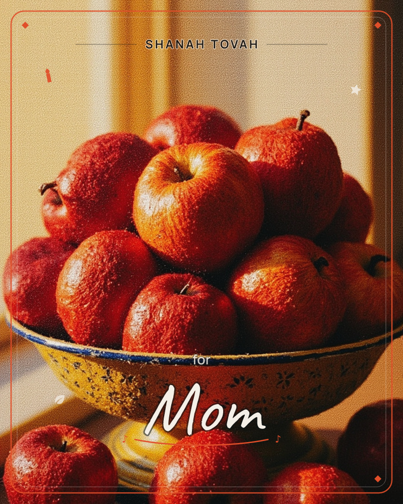 A worn enamel bowl painted with small floral patterns holds a heaping pile of glossy red apples, catching warm afternoon light near a curtained window, a rosh hashanah e-card design