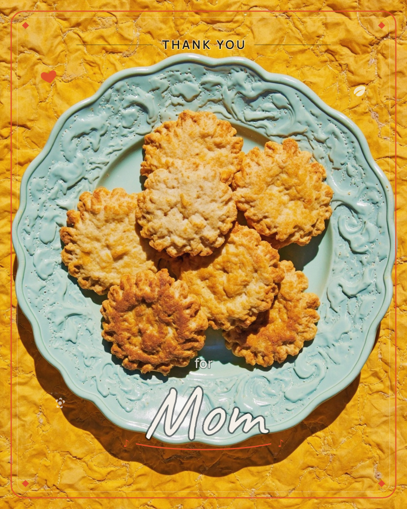A pale mint-green scalloped plate with an embossed floral border holds a stack of golden-brown crimped biscuits, shot from directly above on a crumpled…, a thankyou e-card design