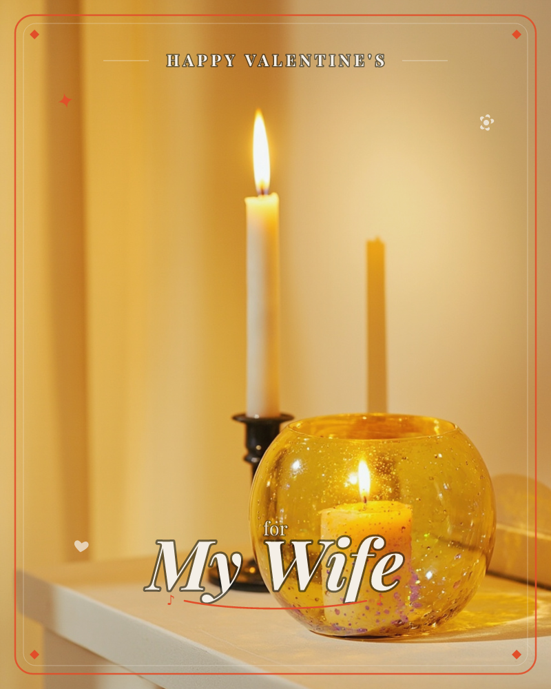 A softly lit tabletop scene glows in warm amber tones, with a tall white taper candle burning in a small black holder beside a golden speckled glass…, a valentine e-card design