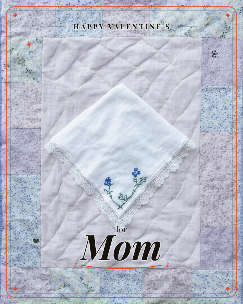 A white lace-edged handkerchief sits diamond-turned atop a lavender patchwork quilt block, embroidered in one corner with a small spray of blue flowers…, a valentine e-card design