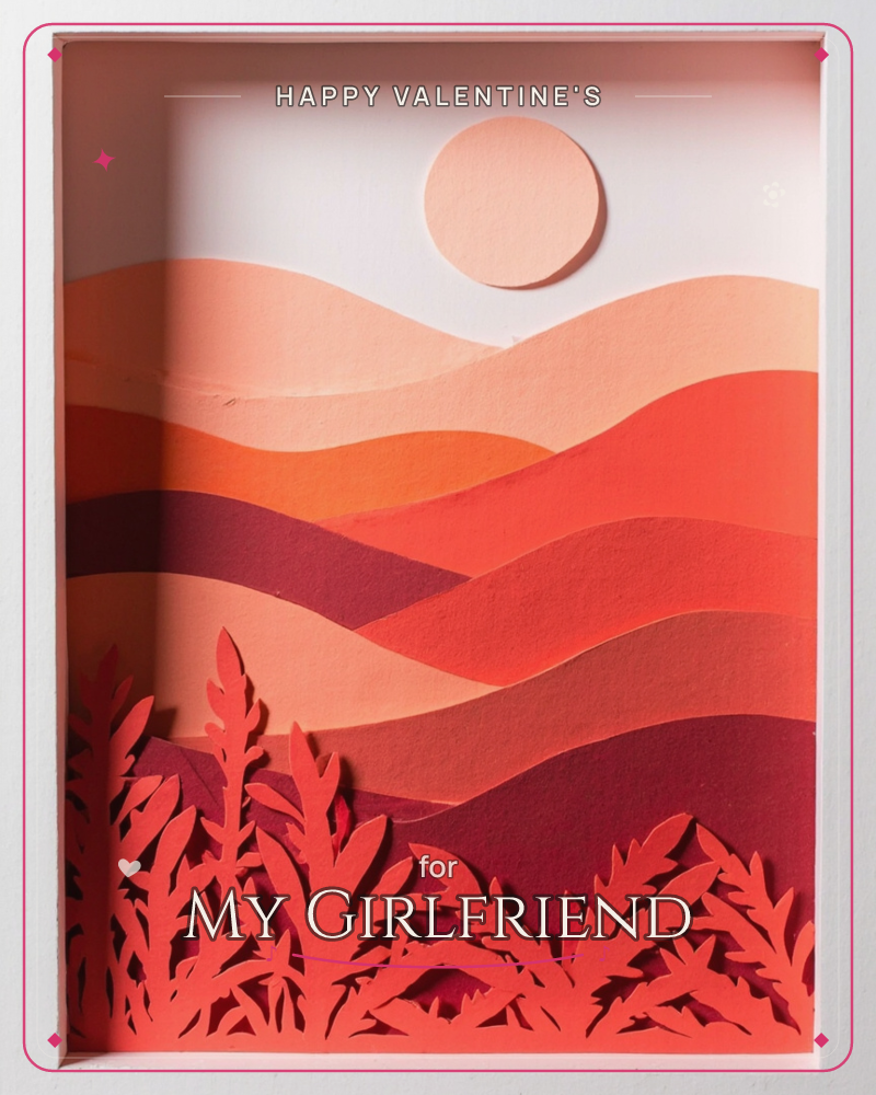 A layered paper-cut diorama shows rolling desert hills built from stacked shades of red, rust and burgundy, with a pale peach sun hovering above the…, a valentine e-card design
