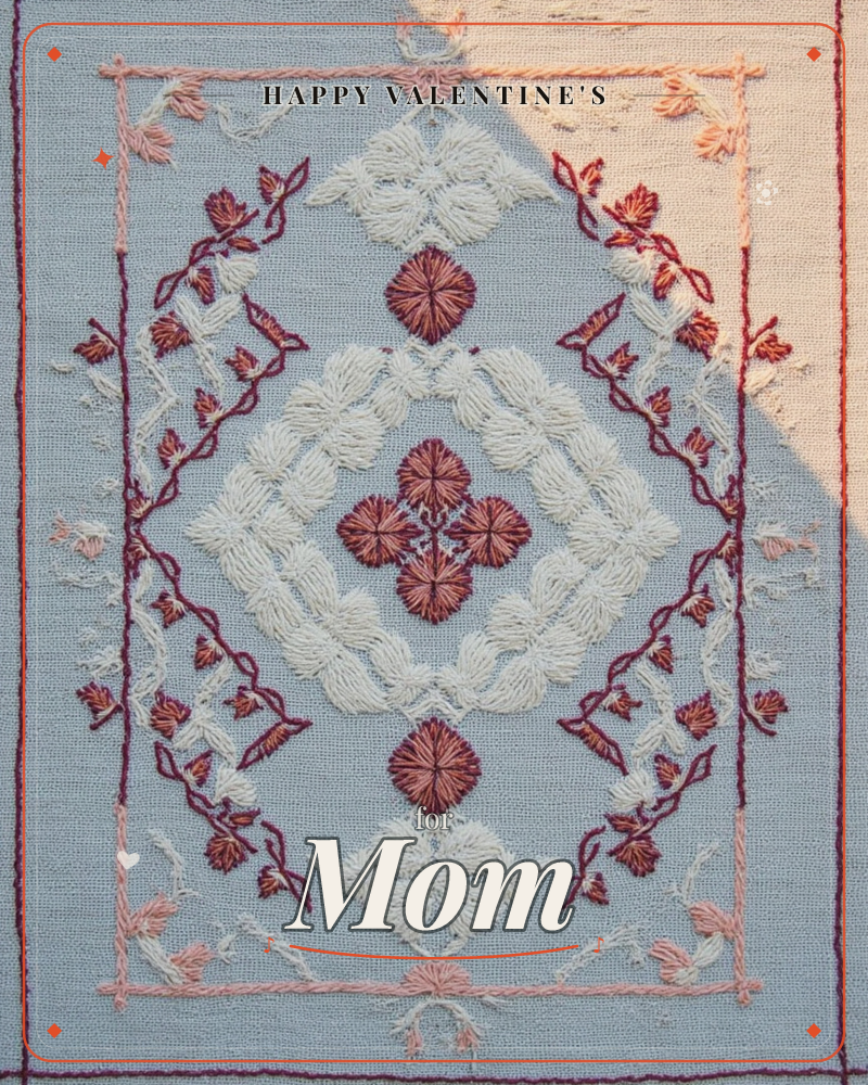 An embroidered textile panel on soft blue fabric shows a symmetrical border of vining leaves and small red blossoms enclosing a diamond lattice of…, a valentine e-card design