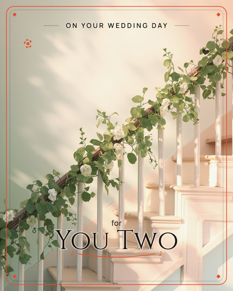 A white staircase railing climbs through soft, dappled light, wound with a garland of green leaves and small white blossoms, a wedding e-card design